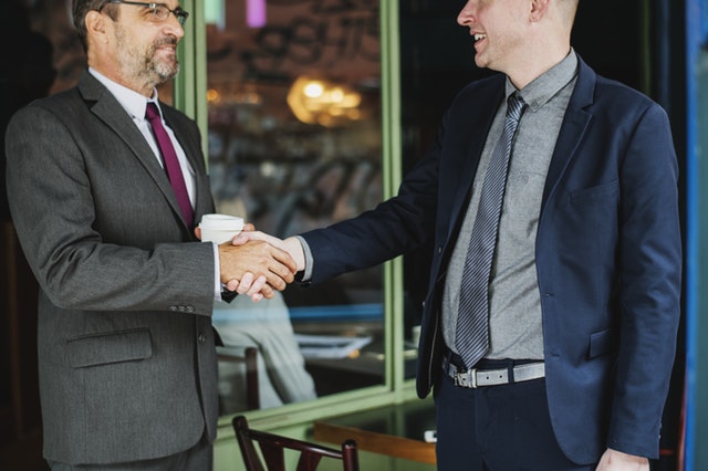 two clients in suits shaking hands