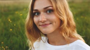 affiliative smile for positive communication lady with beaming ear to ear smile on green background